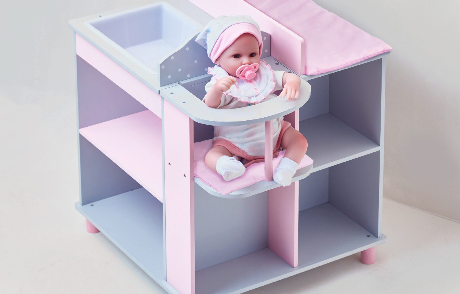 Baby doll in a wooden changing station with mobile