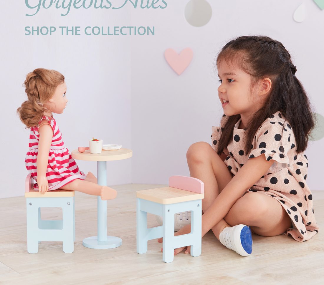 Two girls playing with a doll table set