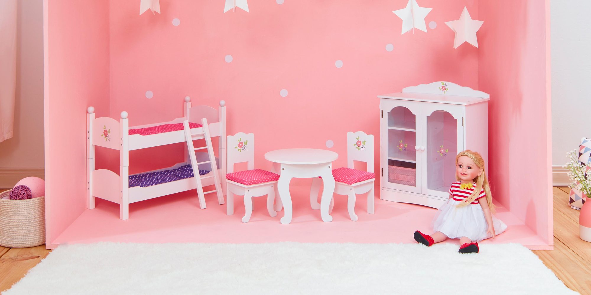 Pink and blue doll furniture room set with an 18-inch doll on the floor